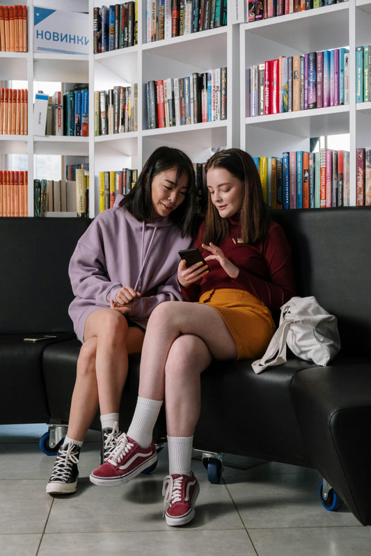 Students looking at a phone in the library